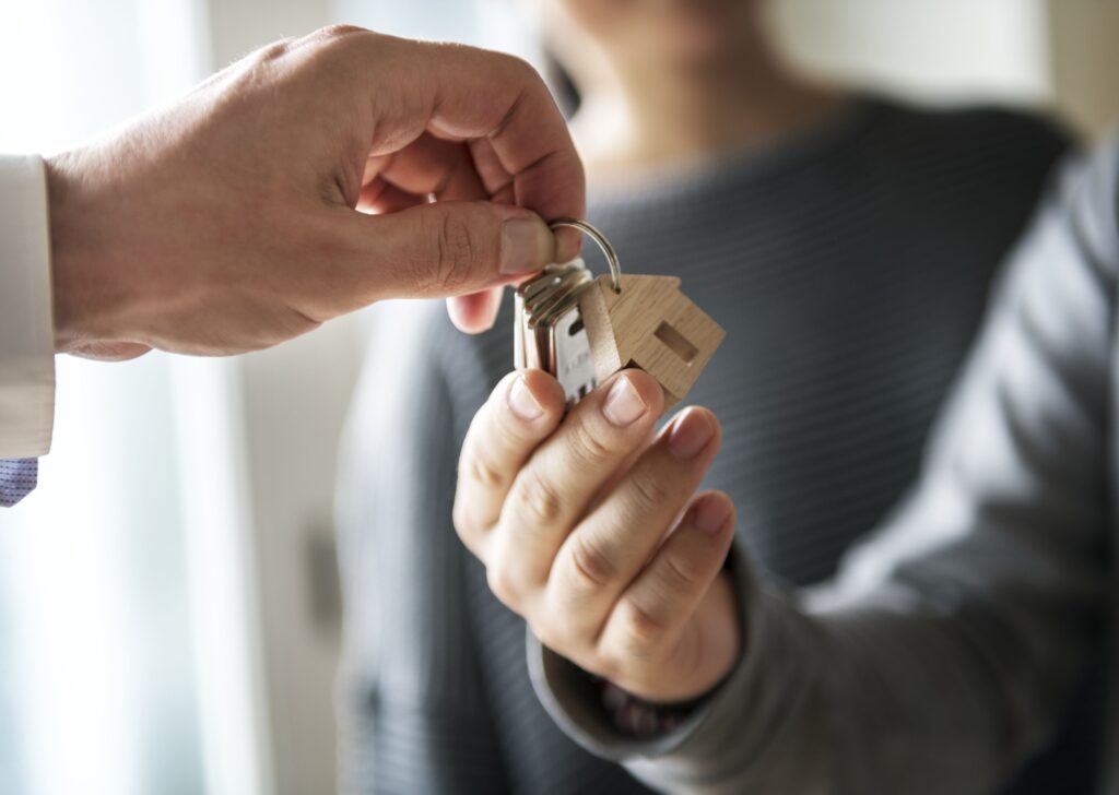 A close-up of a key handover during conveyancing, symbolizing the transfer of home ownership or rental.